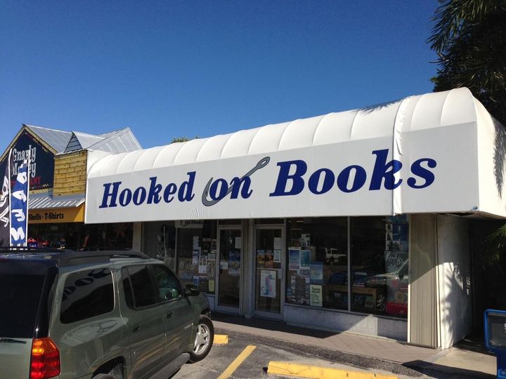 White awning lettered Hooked on Books over a bookstore