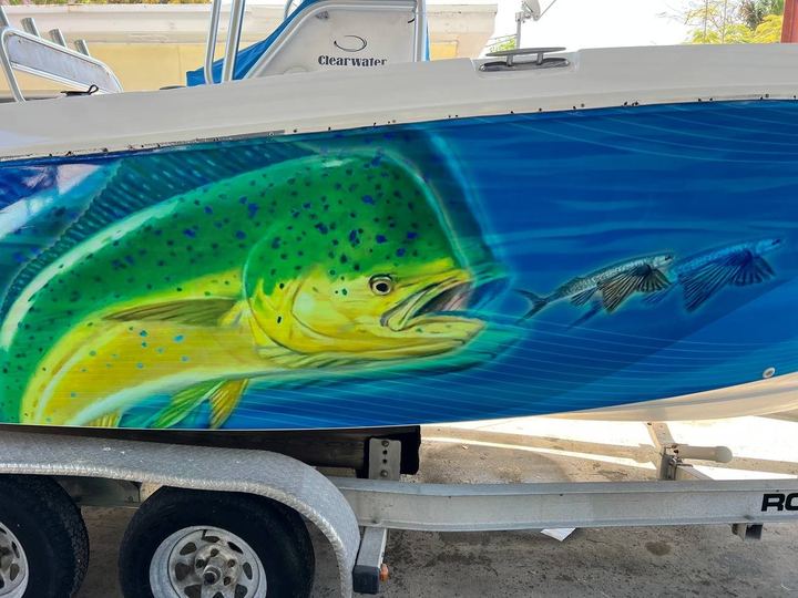 Center console on a trailer wrapped with a mahi chasing flying fish over blue water