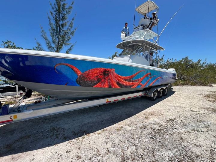 Center console on a trailer wrapped with Wyland's giant red octopus over deep blue water