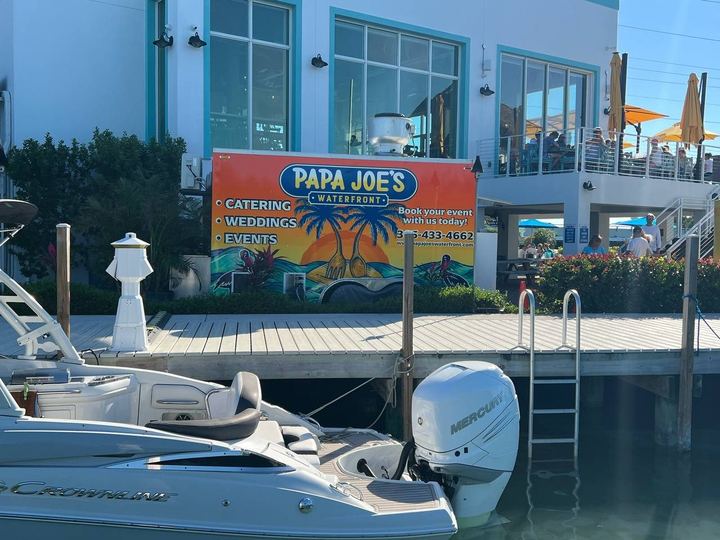 Papa Joe's Waterfront catering, weddings and events sign over a marina dock