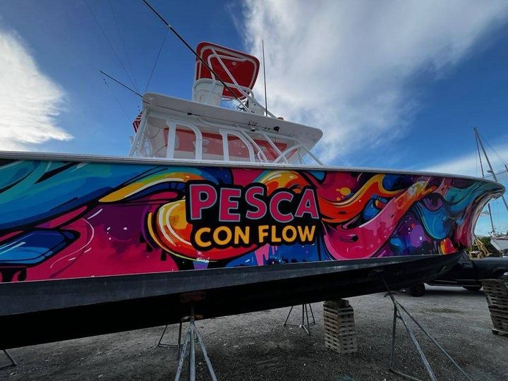 Sportfisher on stands with a bright multicolor wrap lettered Pesca Con Flow