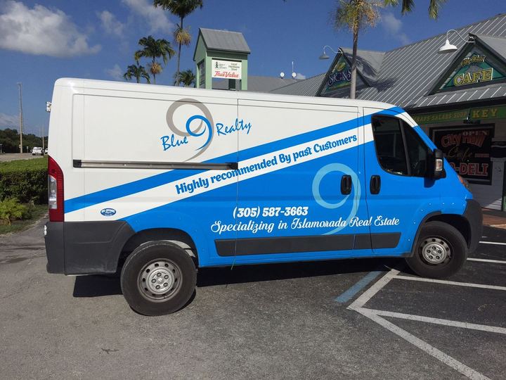 White and blue realty van wrap
