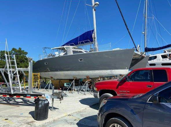 Gray sailing catamaran hull wrap on stands in the boatyard