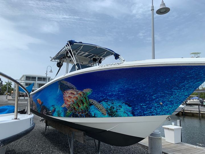 Center console bow wrapped with a sea turtle over a reef