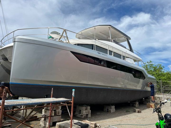 Large power catamaran on blocks wrapped in silver from bow to stern
