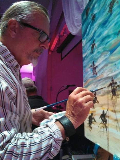 Pasta Pantaleo painting a marine scene on canvas in his studio