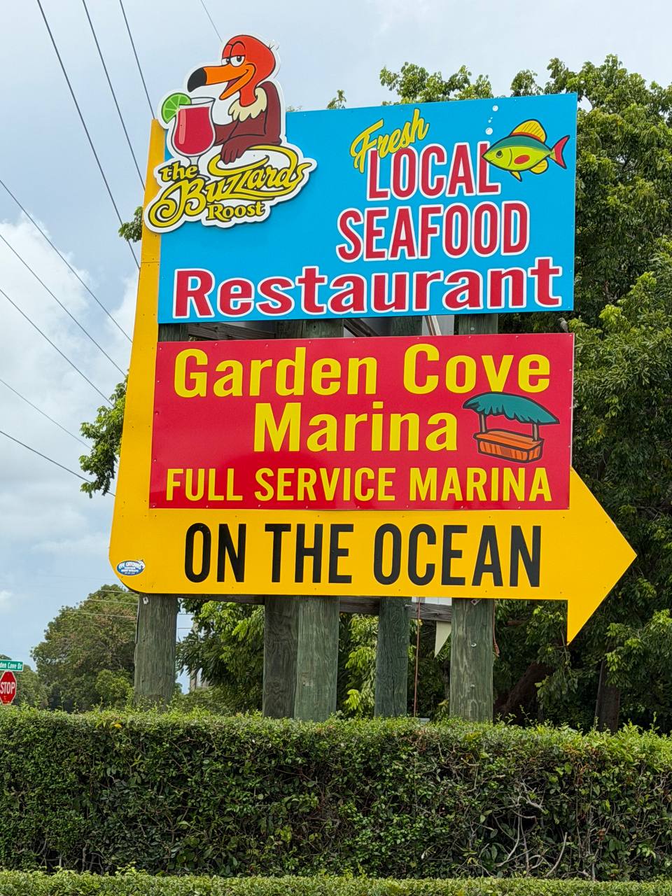 Buzzard's Roost local seafood restaurant and Garden Cove Marina pole sign with an On the Ocean arrow