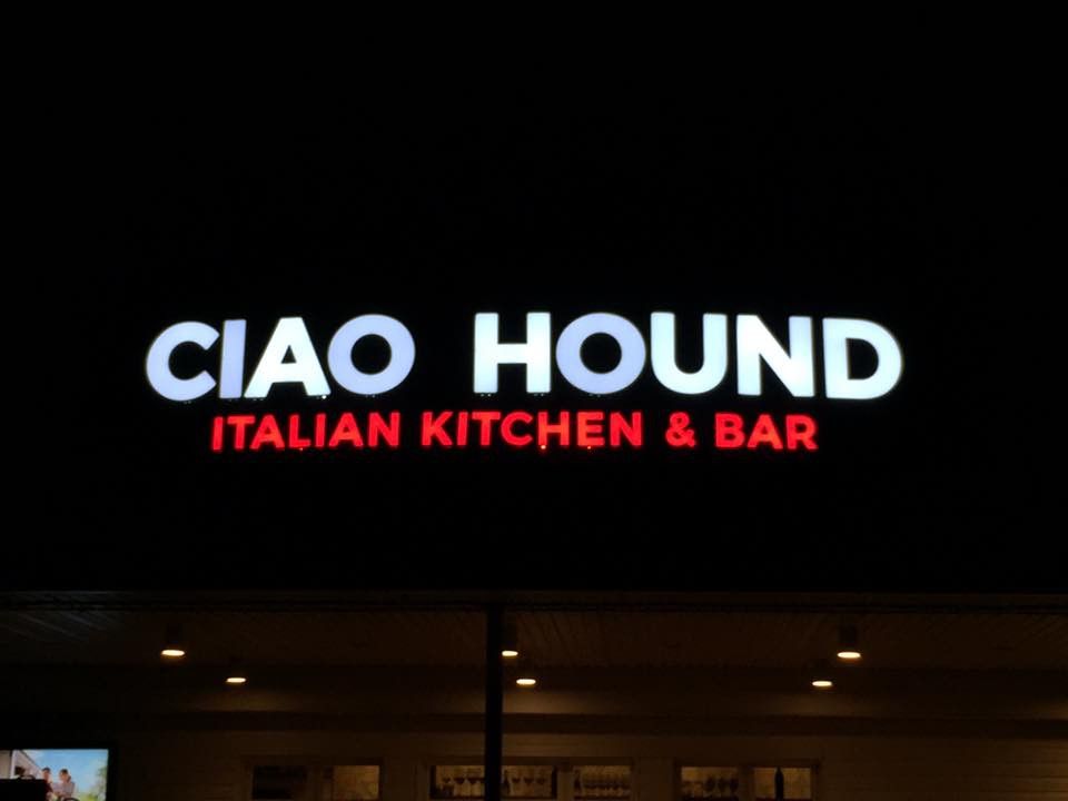 Lit Ciao Hound Italian Kitchen and Bar wall sign at night