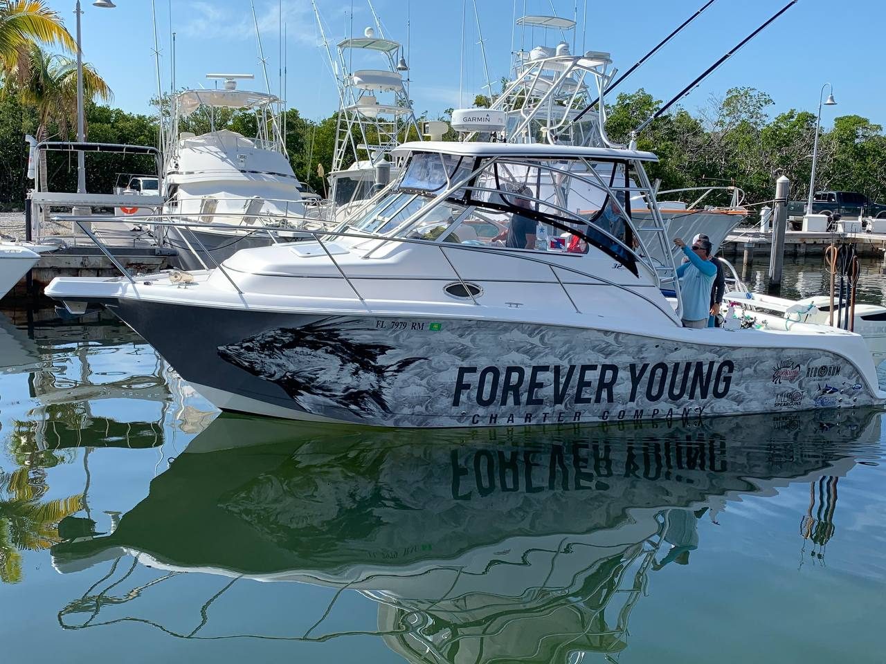 Forever Young Charter Company express cruiser with a black and white fish wrap