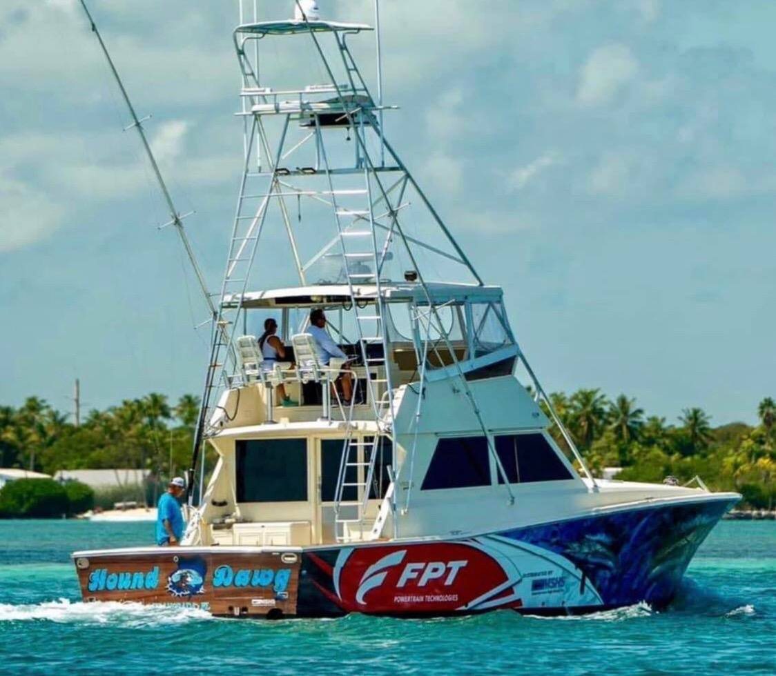 Sportfisher running through turquoise water with a red, white and blue FPT wrap