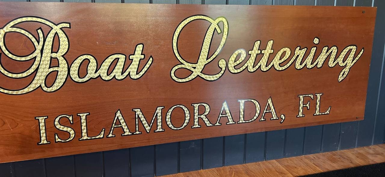 Gold leaf script Boat Lettering and Islamorada FL on a teak-look panel
