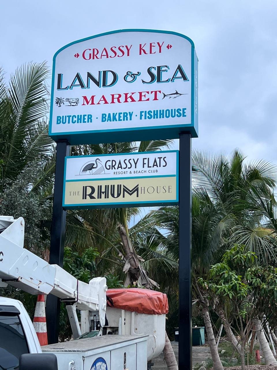 Grassy Key Land and Sea Market pole sign with Grassy Flats and Rhum House panels