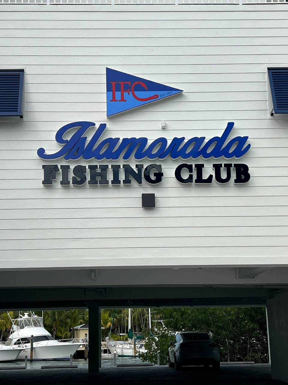 Islamorada Fishing Club raised letters and pennant logo on a white clapboard building
