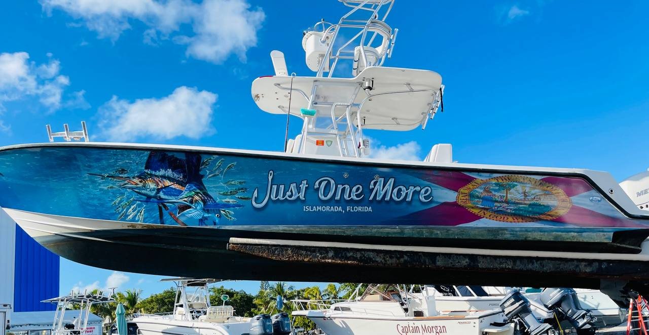 Sportfisher on a lift with a sailfish wrap lettered Just One More