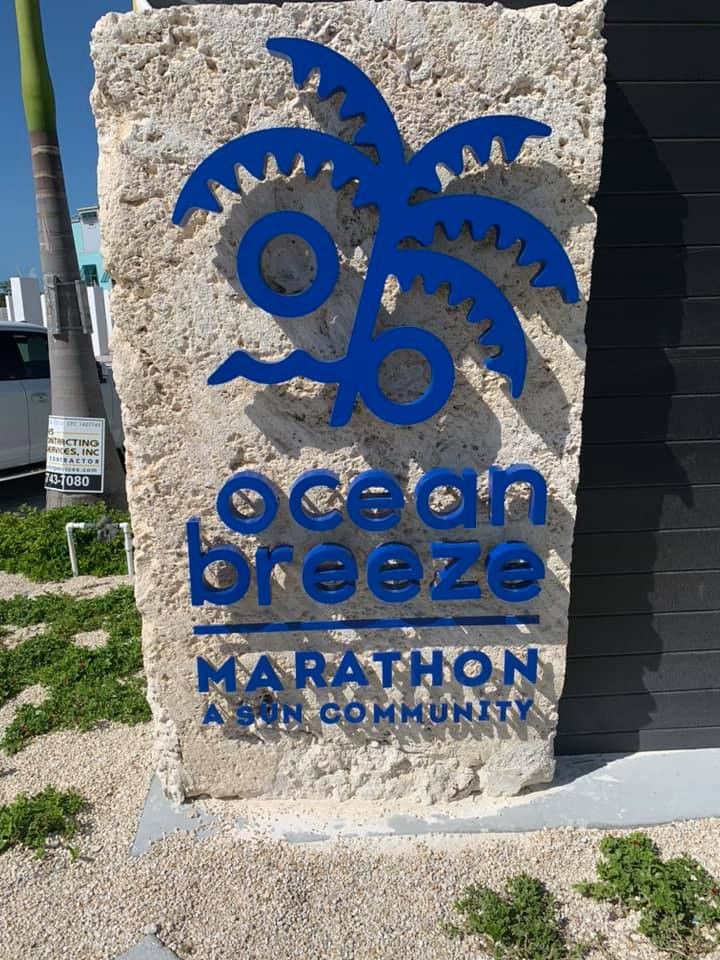 Ocean Breeze Marathon stone monument sign with a blue palm logo