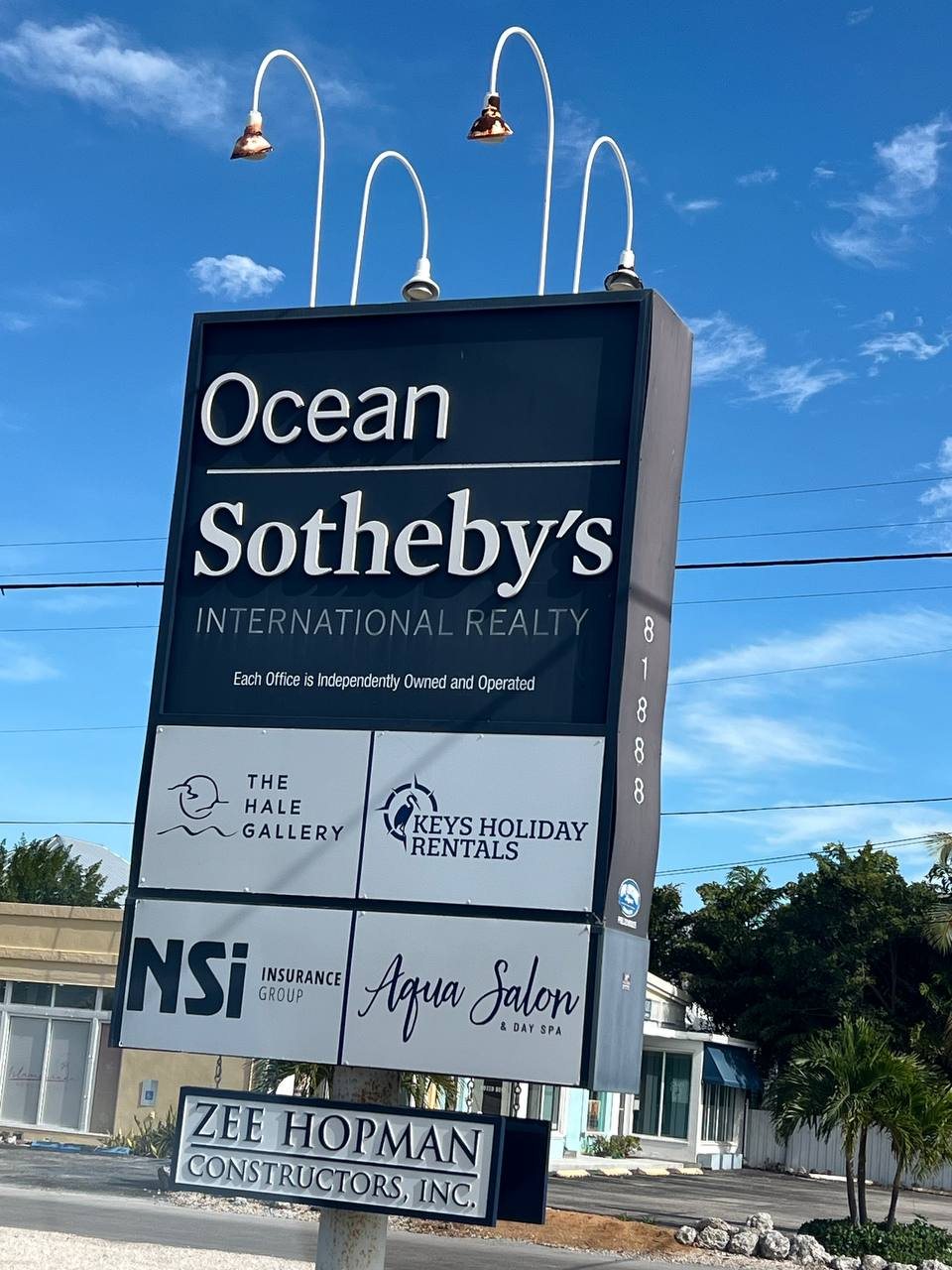 Ocean Sotheby's International Realty pole sign with tenant panels and gooseneck lights