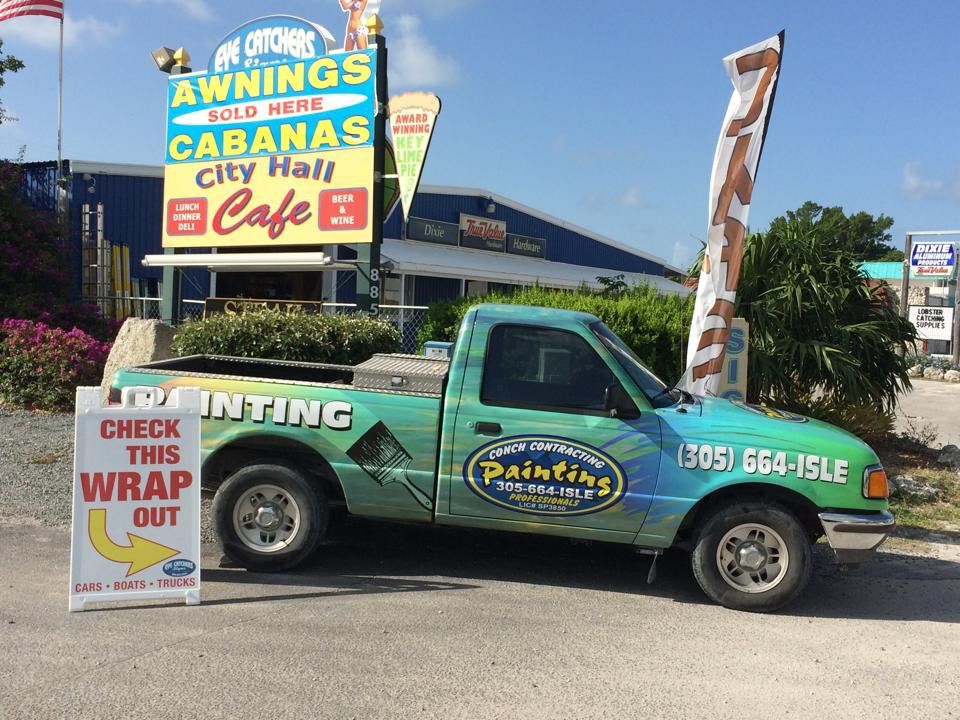 Wrapped painting contractor truck parked under the Eye Catchers Signs, City Hall Cafe roadside sign at mile marker 88.5