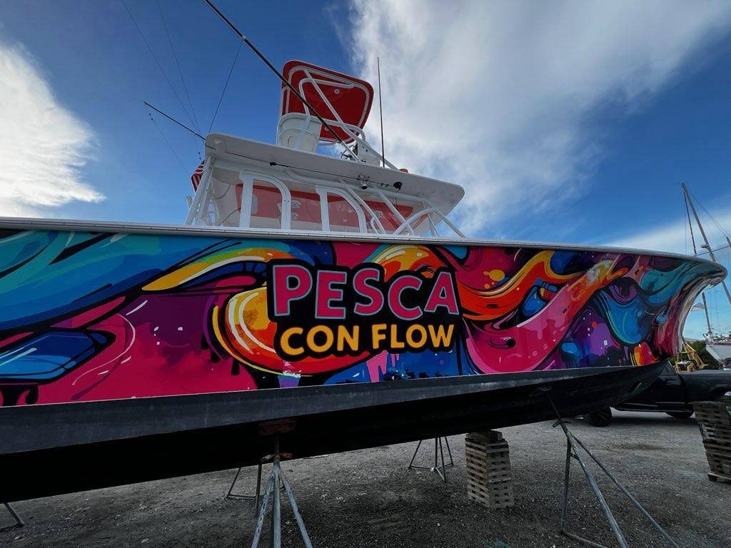 Sportfisher on stands with a bright multicolor wrap lettered Pesca Con Flow
