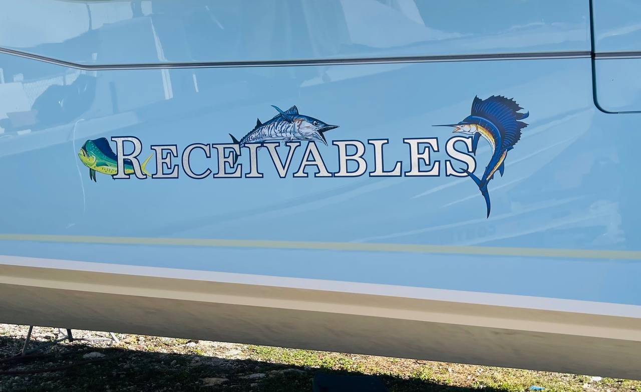 Receivables boat name in silver and navy with a mahi, a wahoo and a sailfish