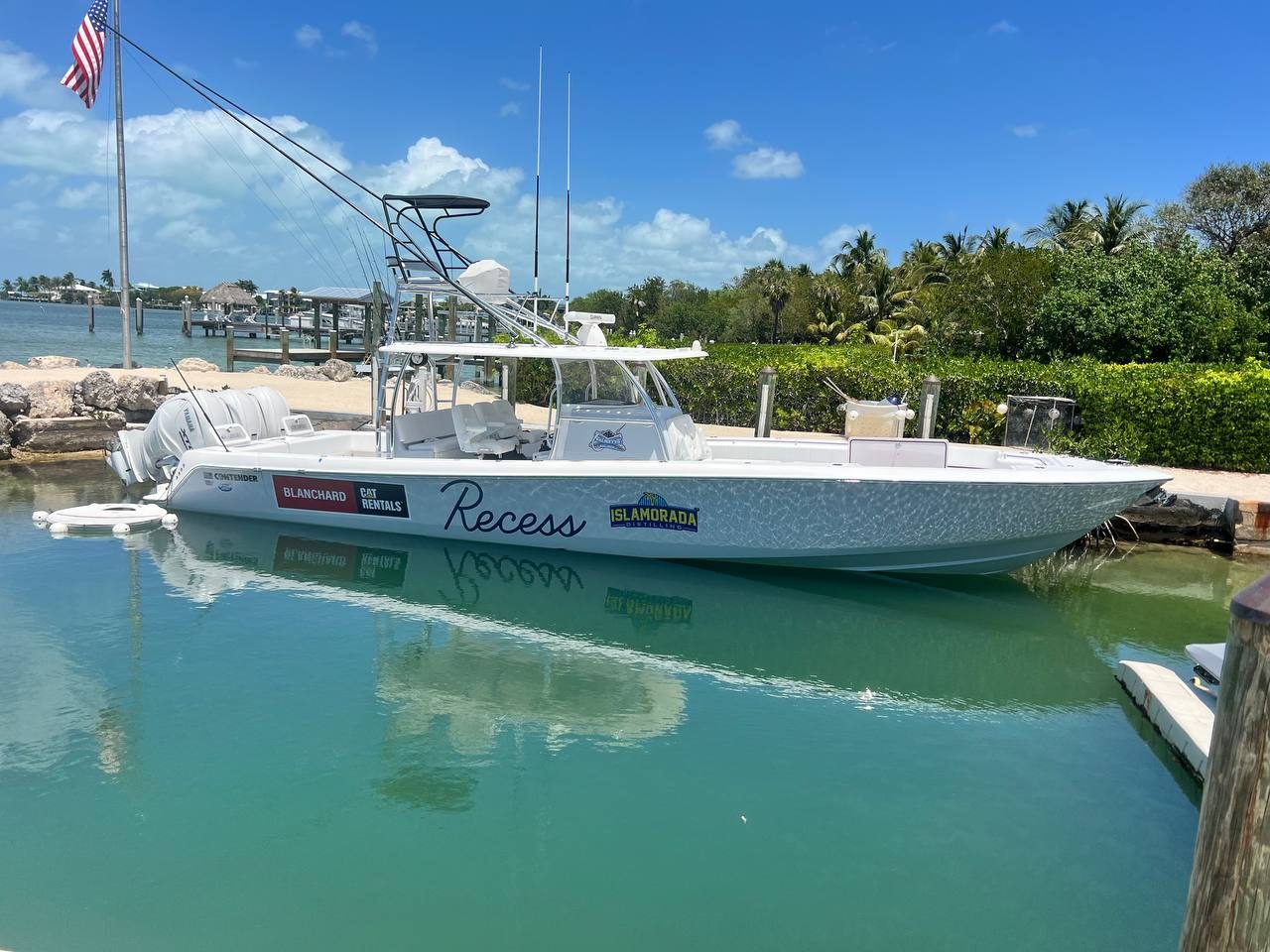 Center console docked in clear water with Recess script lettering
