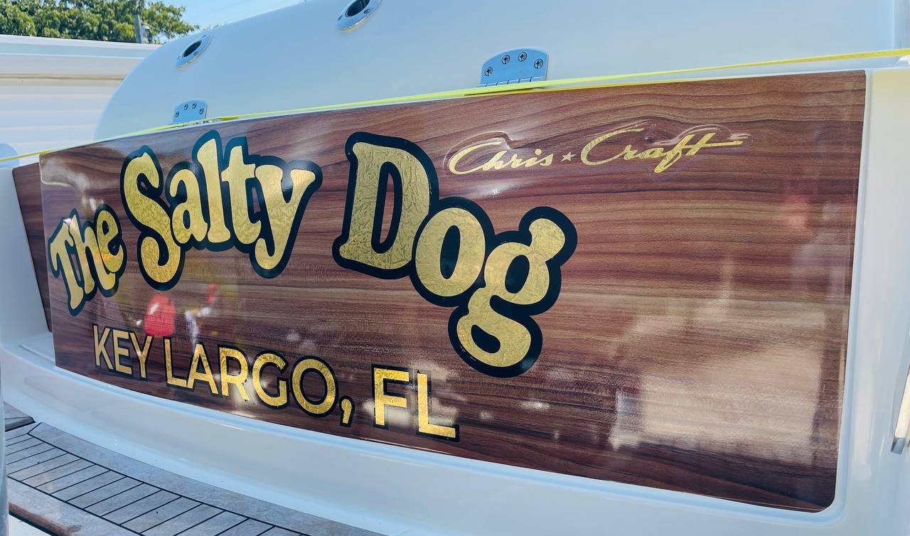 The Salty Dog transom in gold leaf script with a Key Largo FL hailing port on teak