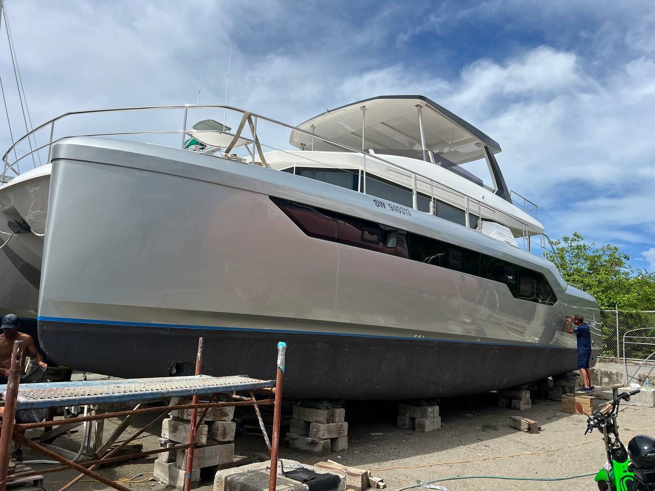 Large power catamaran on blocks wrapped in silver from bow to stern
