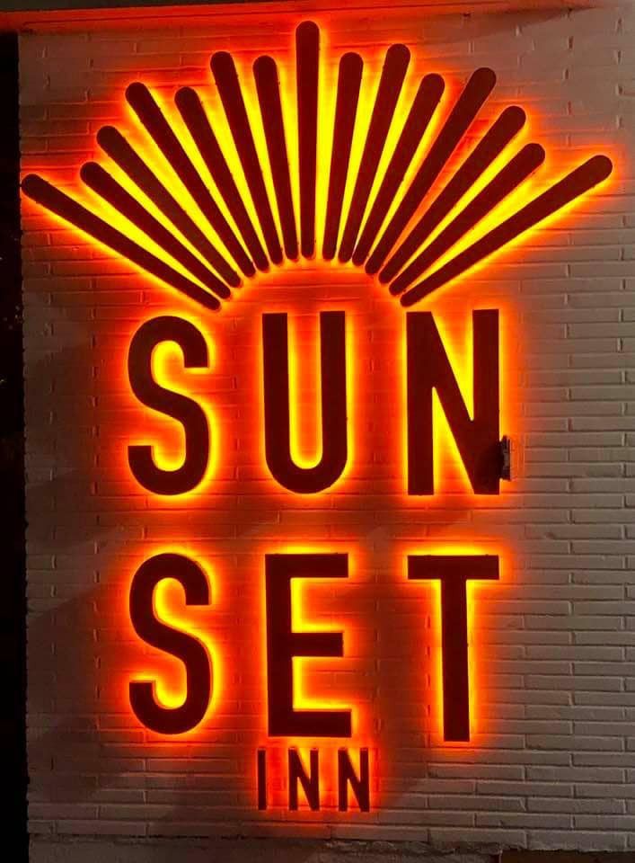 Glowing orange backlit Sunset Inn sign