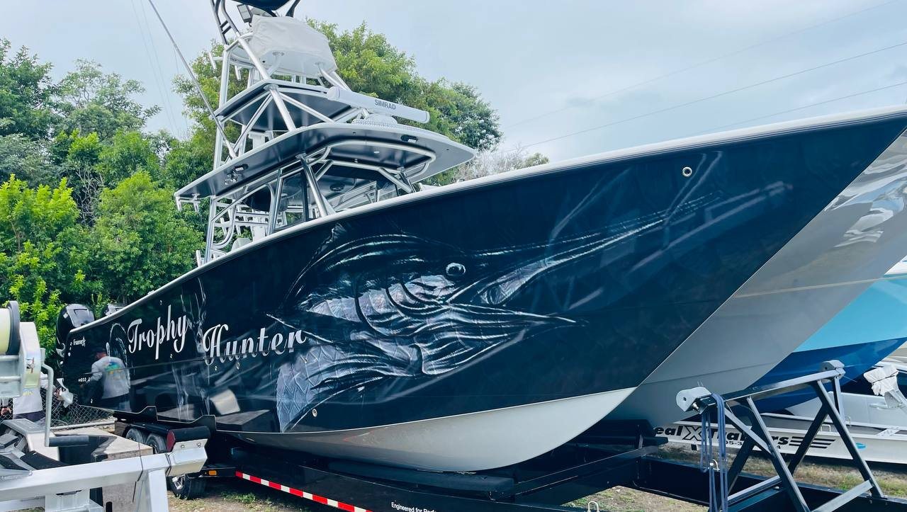Sportfisher on a trailer wrapped in deep blue with a marlin and Trophy Hunter script
